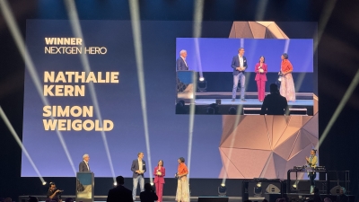 The photo shows the two winners Nathalie Kern and Simon Weigold on stage in the NextGen Hero 2025 category.