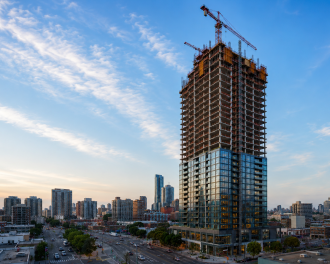 An AI-generated image of a city with a high-rise building in the foreground, the lower half of which has already been completed.