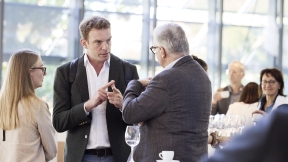 Photo of a group of people discussing and networking at this year's "Educa25" symposium on digital identities.