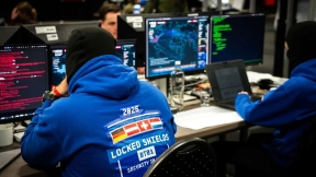 Photo of a room with cyber security experts sitting at computers and participating in a cyberdefense exercise 