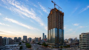 An AI-generated image of a city with a high-rise building in the foreground, the lower half of which has already been completed.