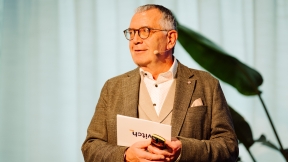 Urs Eppenberger is standing on stage and presenting the Domain Pulse 2026